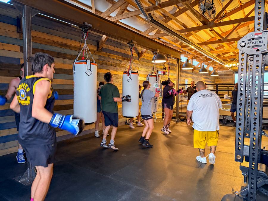 A boxer working the heavy bag with the bag line behind him
