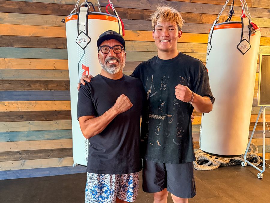 Two club members posing between the heavy bags