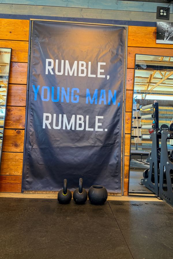 A banner on the gym wall reading Rumble, Young Man, Rumble