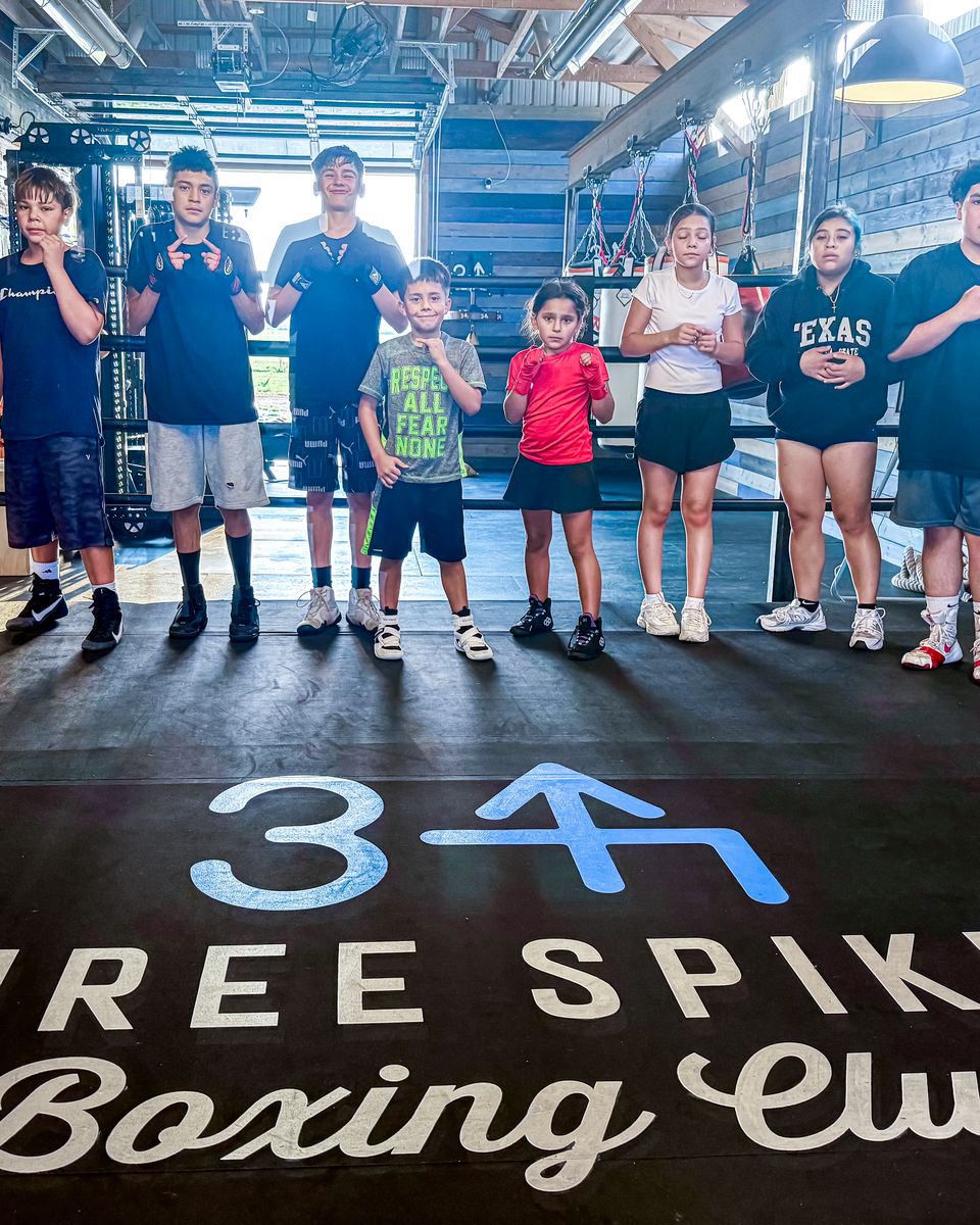Club members and guests lined up above the Three Spikes logo on the ring floor